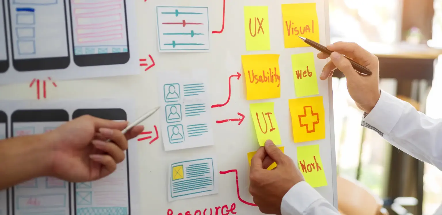 Flipchart mit Post-its und Hand die darauf zeigt