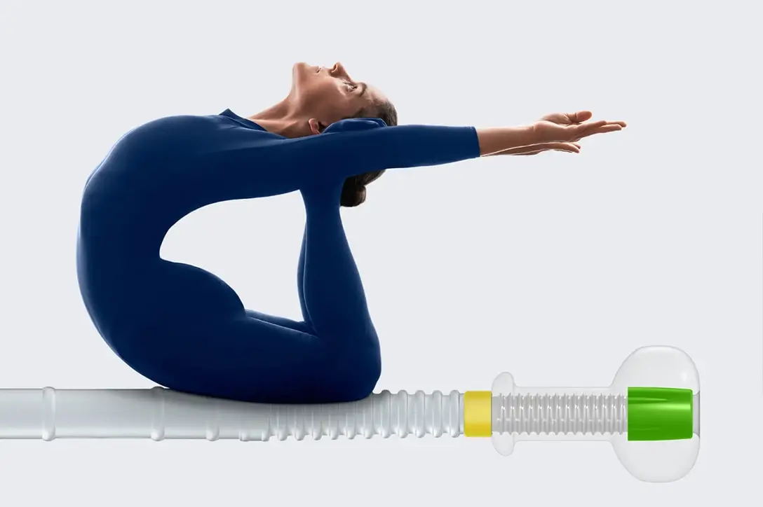 Remy & Remy Newsletterbeitrag Stuhlmanagement in der Intensivpflege Teaserbild eine Turnerin in blauem Gymnastikanzug die au einem überdimensionalgroßen Katheter turnt
