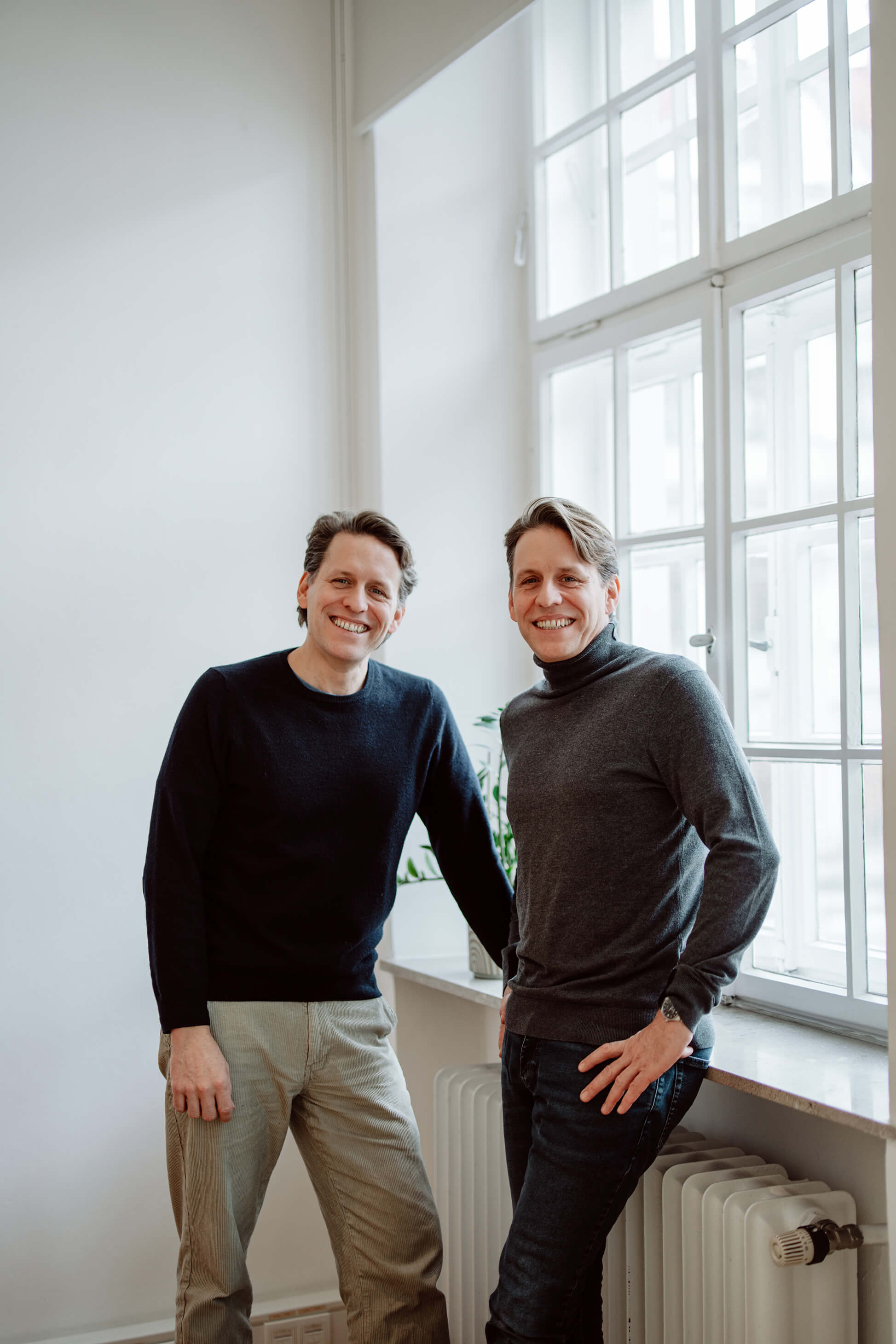 Die beiden lachenden Geschäftsführer von Remy & Remy im Agenturbüro während der strategischen Arbeit an Healthcare-Marketing- und Markenentwicklungsprojekten