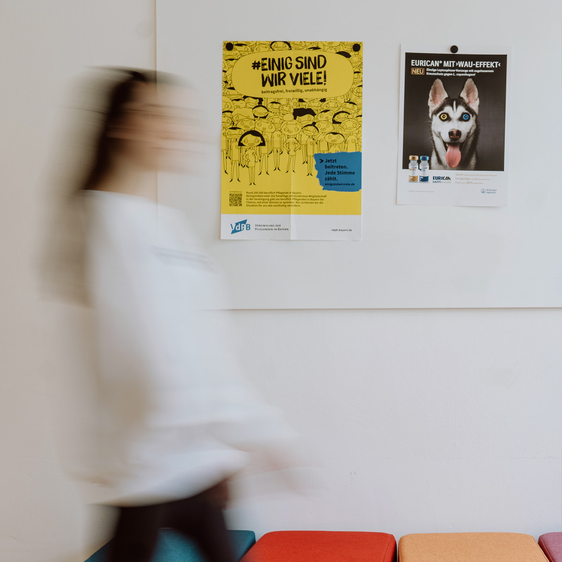 Mitarbeiterin läuft durch das fröhlich, bunt eingerichtete Agenturgebäude