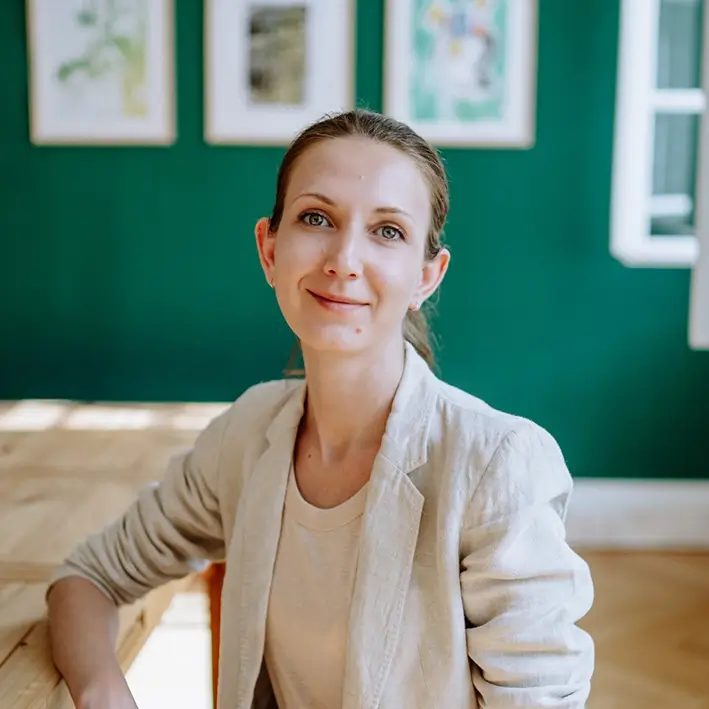 Porträt von Mitarbeiterin vor grüner Bilderwand tätig als UI-/UX-Designerin & digital Managerin bei Remy & Remy Healthcare Kommunikation