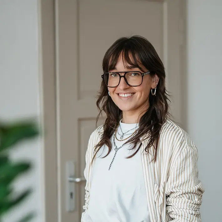 Portrait von Mitarbeiterin mit moderner Brille und braunen langen Haaren tätig als Junior-Artdirektorin bei Remy & Remy Healthcare Kommunikation