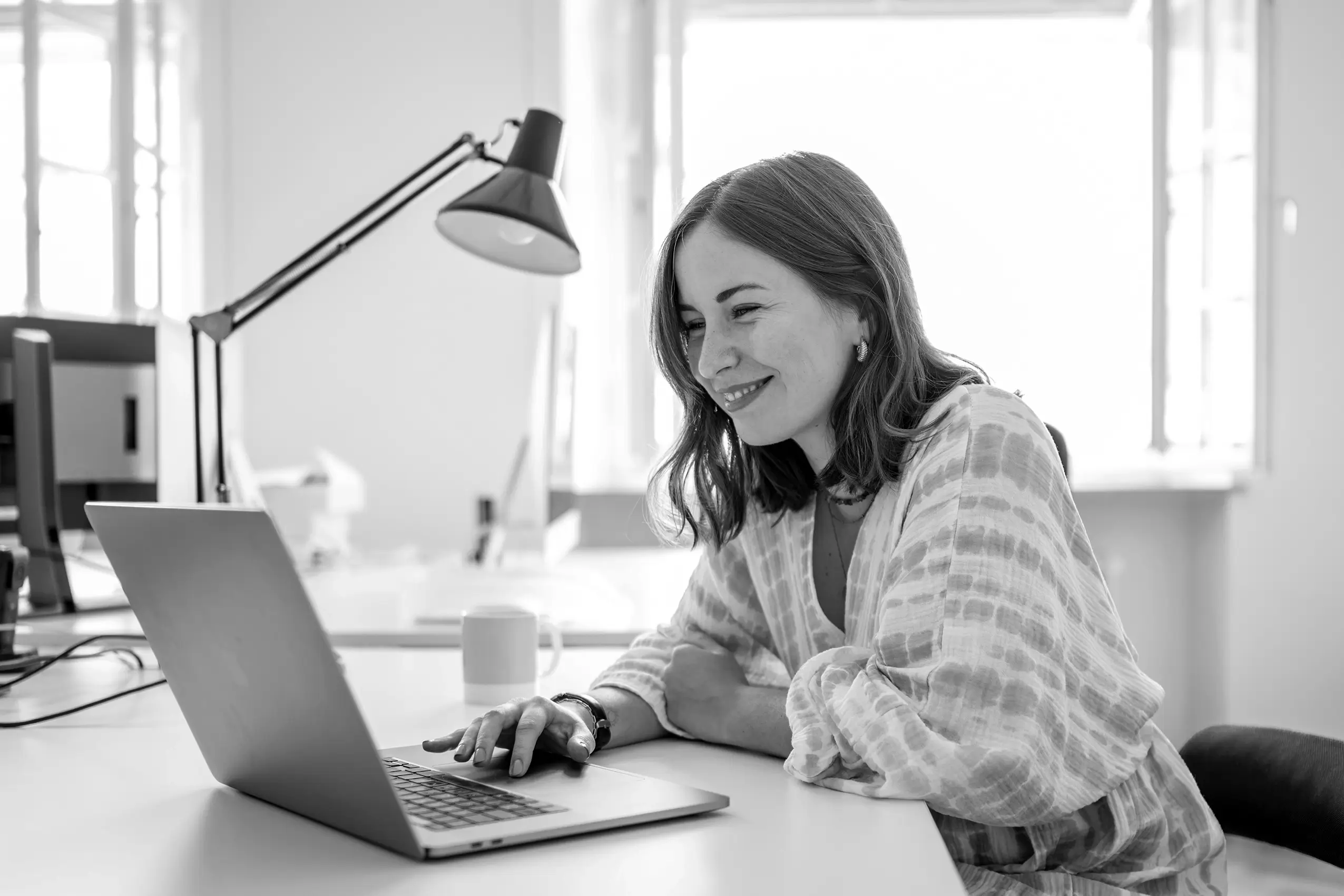 Textredaktion Remy&Remy Healthcare-Agentur arbeitet lachend am Computer im Büro an Projekten für Markenentwicklung und Kommunikation