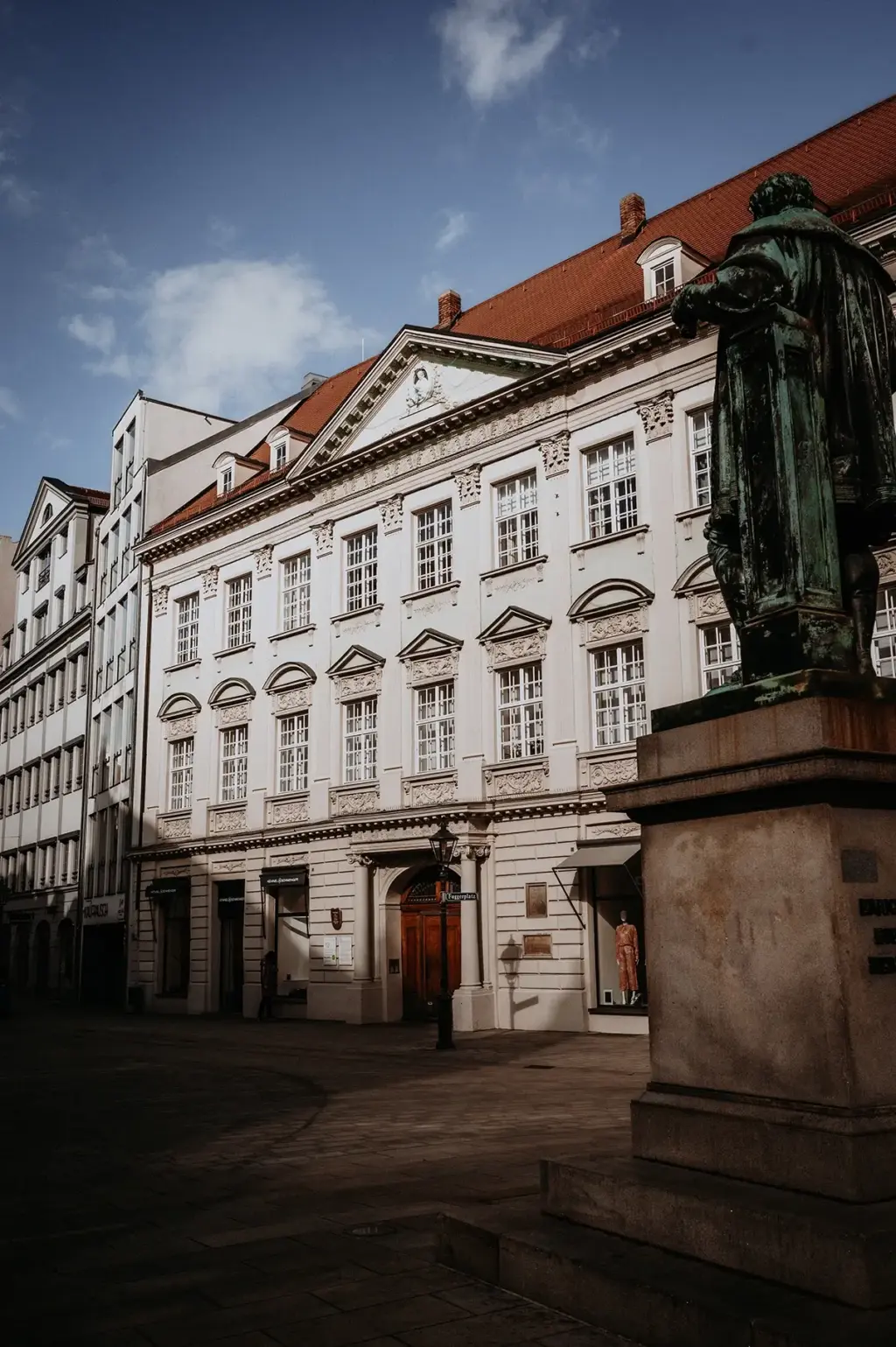Platz mit Statue und Aussenansicht des Gebäudes aus dem 16. Jahrhundert in dem sich die Büroräume von Remy&Remy Healthcare Kommunikation befinden