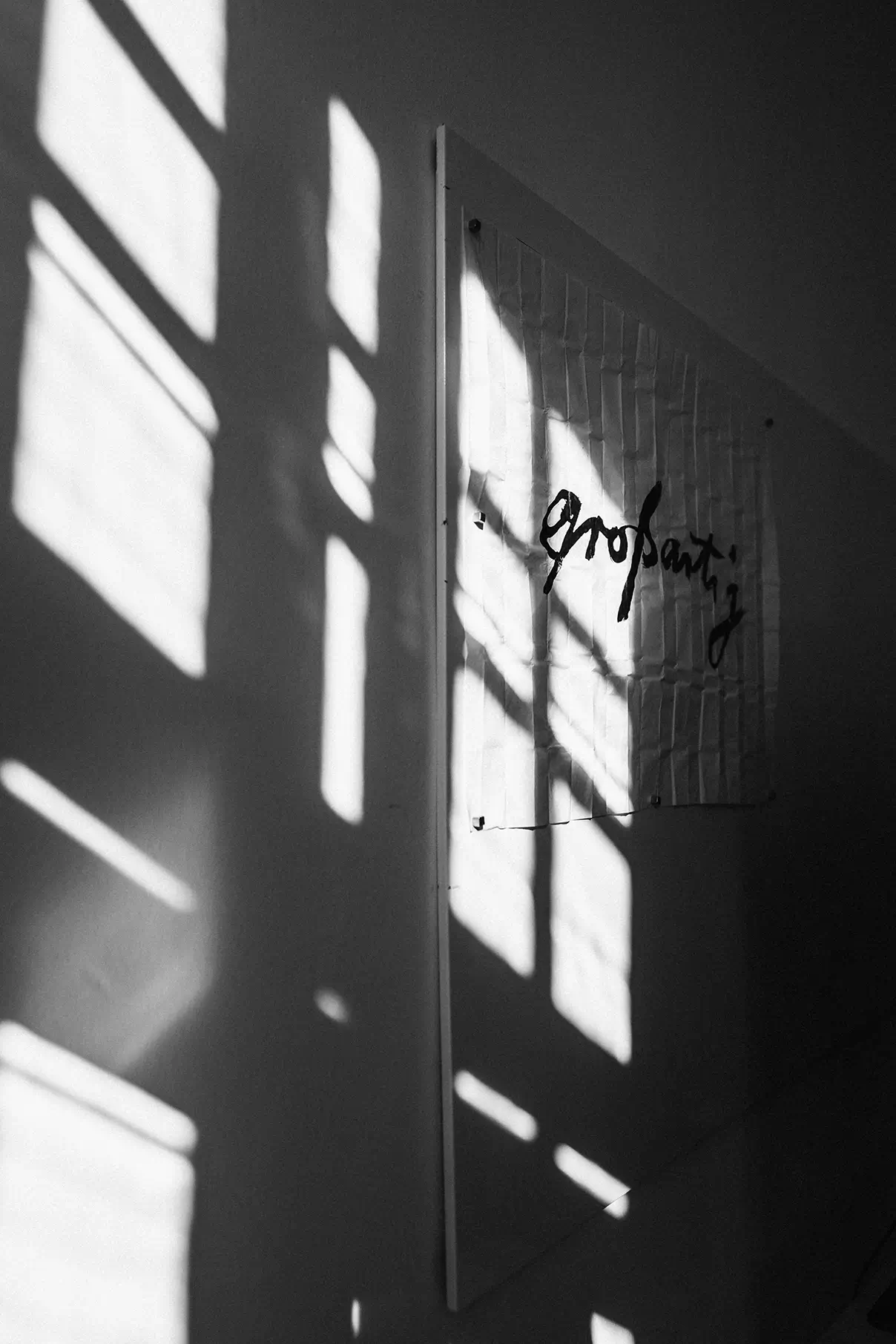 Sonnenlicht fällt auf eine weiße Wand im Agenturbüro von Remy & Remy, auf der das Wort „großartig“ in verschnörkelter Typografie als Ausdruck kreativer Marken- und Kommunikationsarbeit im Healthcare- und MedTech-Bereich inszeniert ist