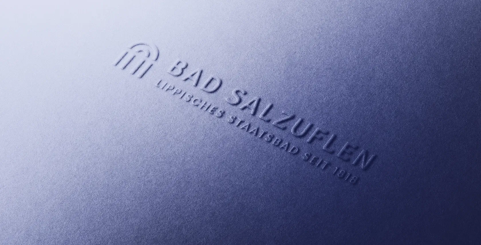 Referenzprojekt Bad Salzuflen - Mockup in Form des Logos welches in dunkelblaue Pappe gepresst wurde.