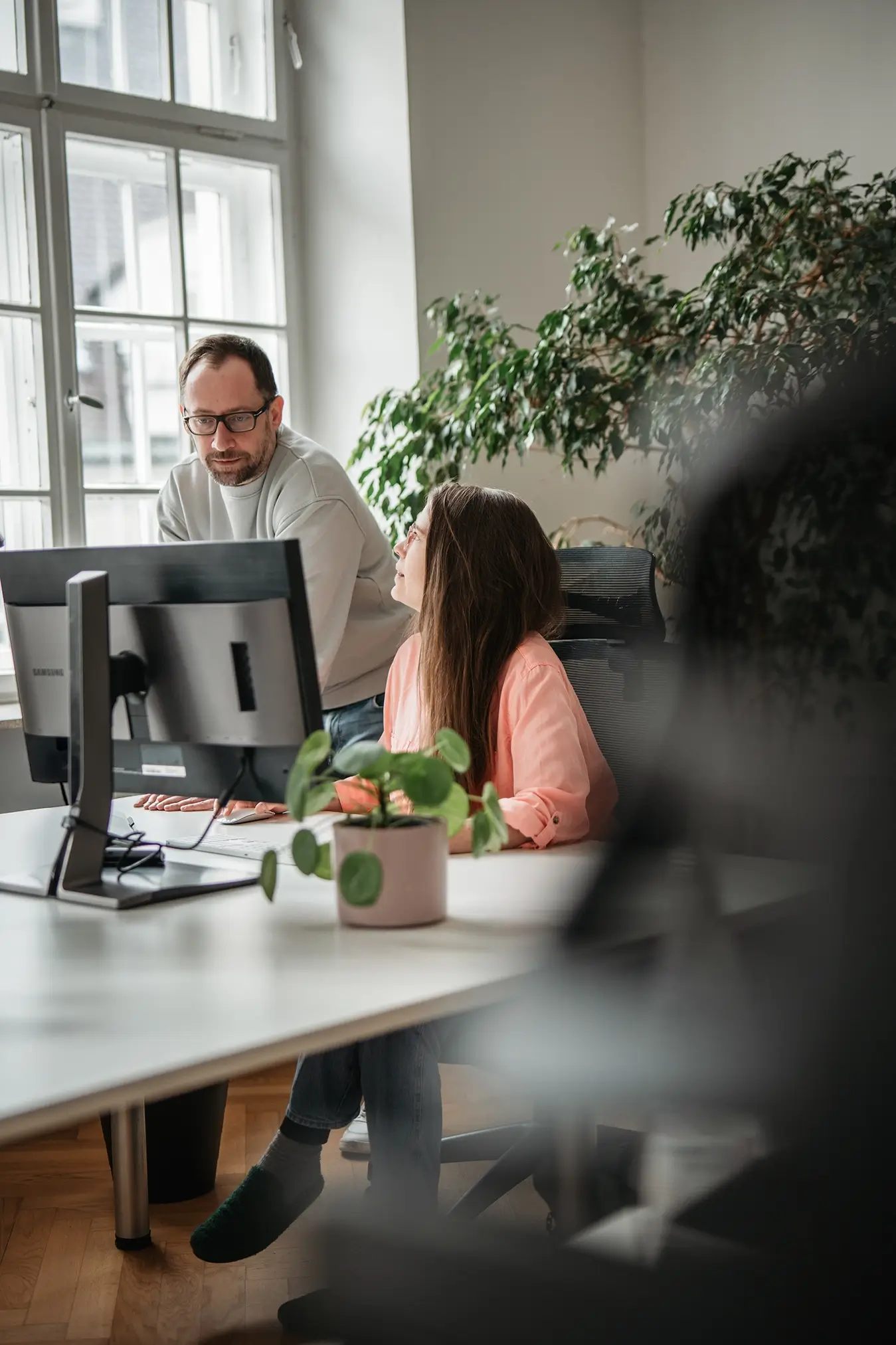 Designer und Projektmanagerin der Remy&Remy Healthcare-Agentur im Gespräch am Arbeitsplatz über ein Projekt zur Entwicklung von Marken- und Kommunikationslösungen
